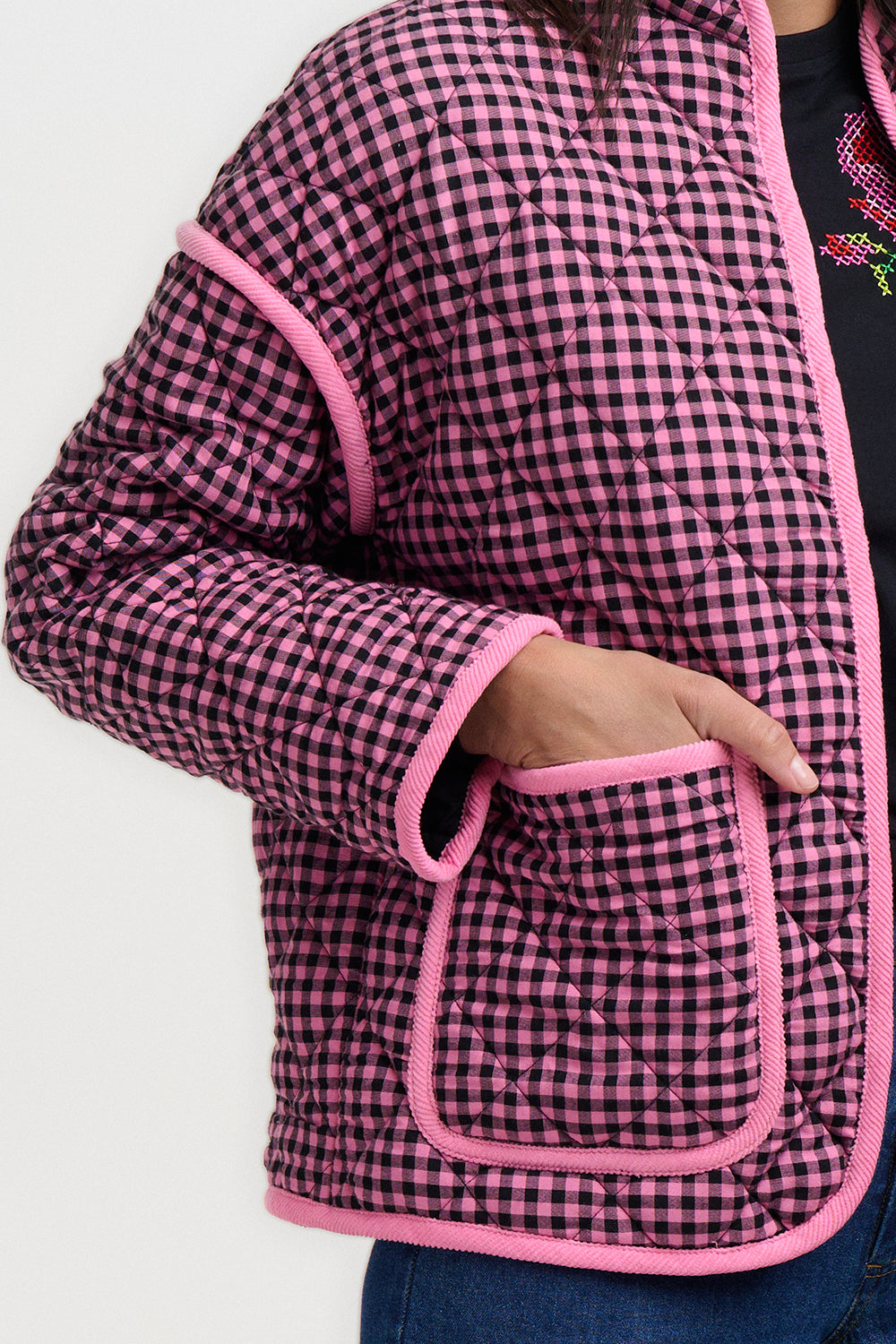 Pink and black checkered jacket with pink trim on a white background