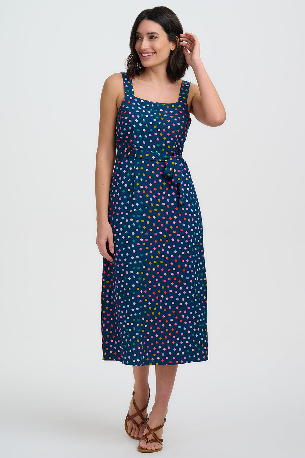 Woman wearing a blue dress with colorful polka dots on a white background