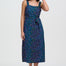 Woman wearing a blue dress with colorful polka dots on a white background