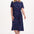 Woman wearing a navy dress with colorful polka dots on a white background