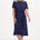 Woman wearing a navy dress with colorful polka dots on a white background