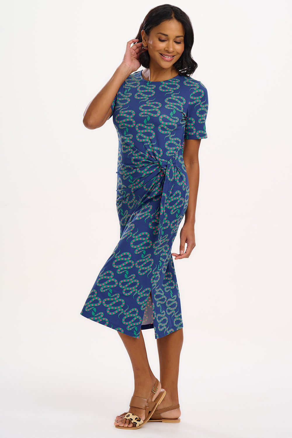 A model wearing a bright navy blue jersey midi dress with a star and snake pattern, featuring short sleeves and side split hem.