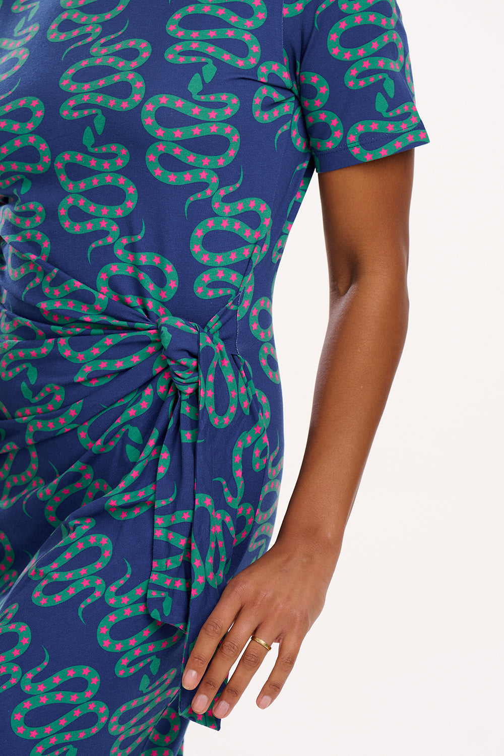 A model wearing a bright navy blue jersey midi dress with a star and snake pattern, featuring short sleeves and side split hem.