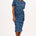 A model wearing a bright navy blue jersey midi dress with a star and snake pattern, featuring short sleeves and a waist tie.