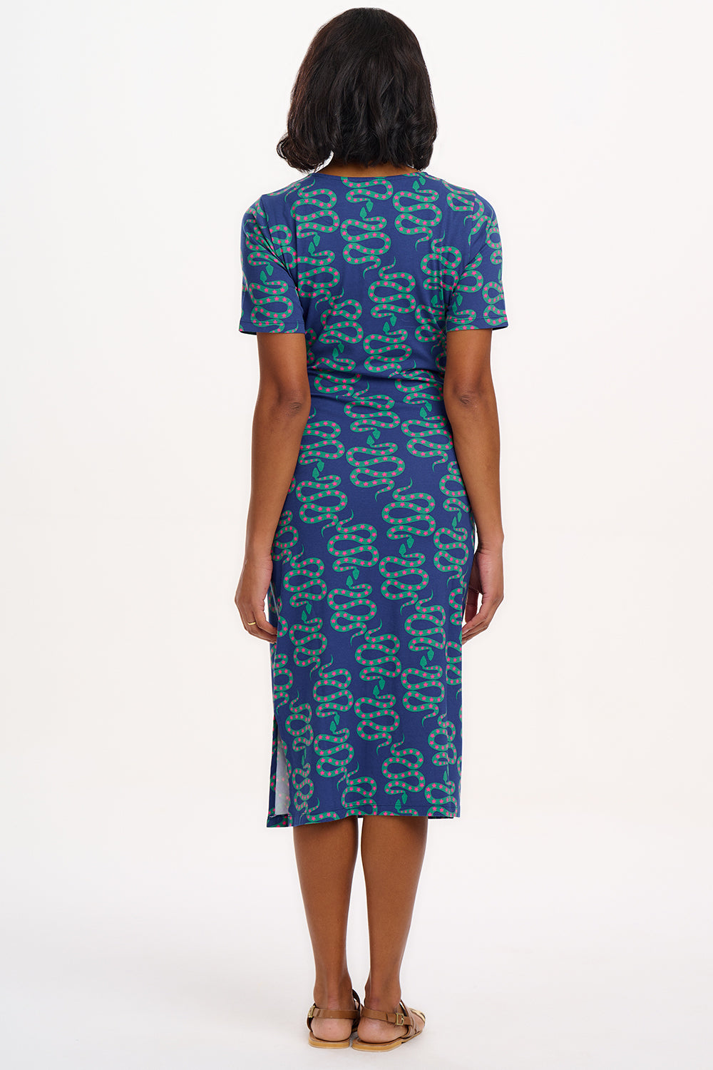 A model wearing a bright navy blue jersey midi dress with a star and snake pattern, featuring short sleeves and side split hem.