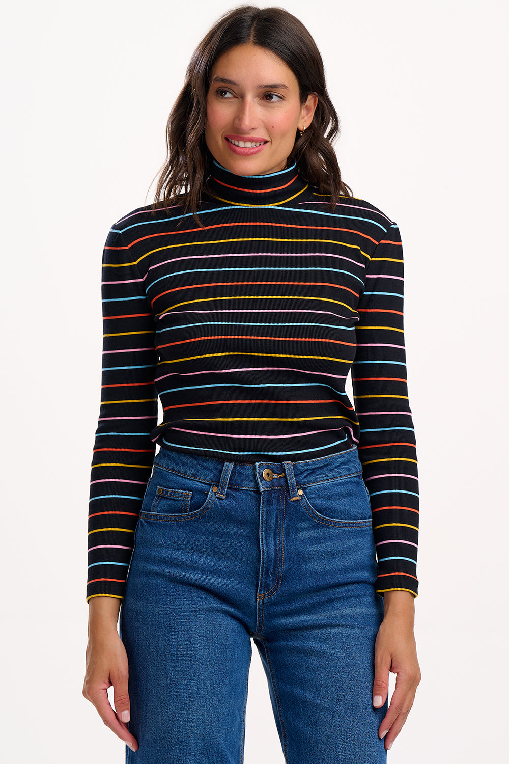 Woman wearing a striped turtleneck and jeans on a white background