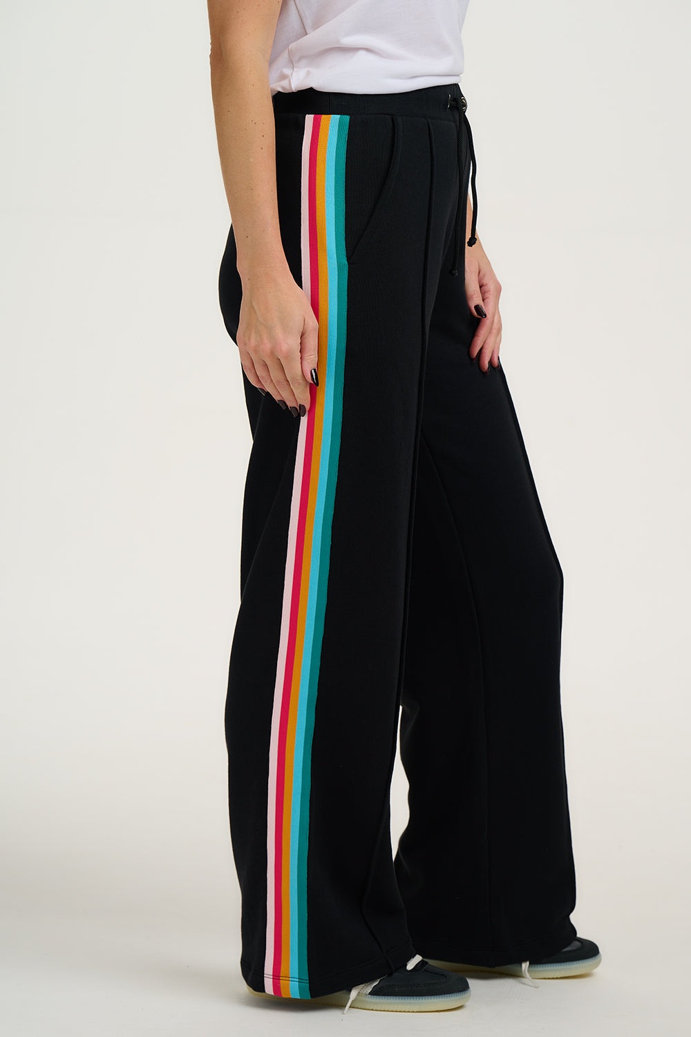 Black wide-leg pants with colorful stripes on a white background