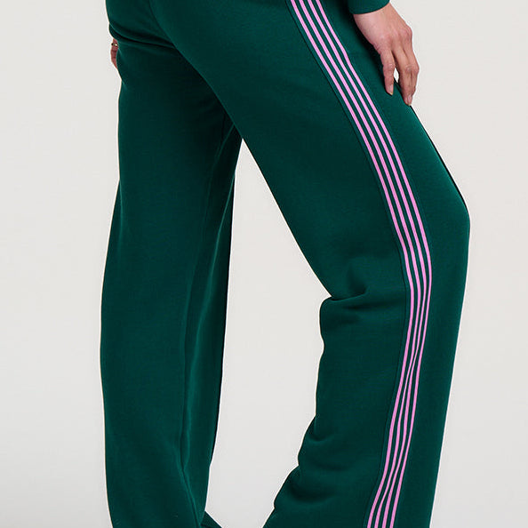 Person wearing a green tracksuit with pink stripes on a white background