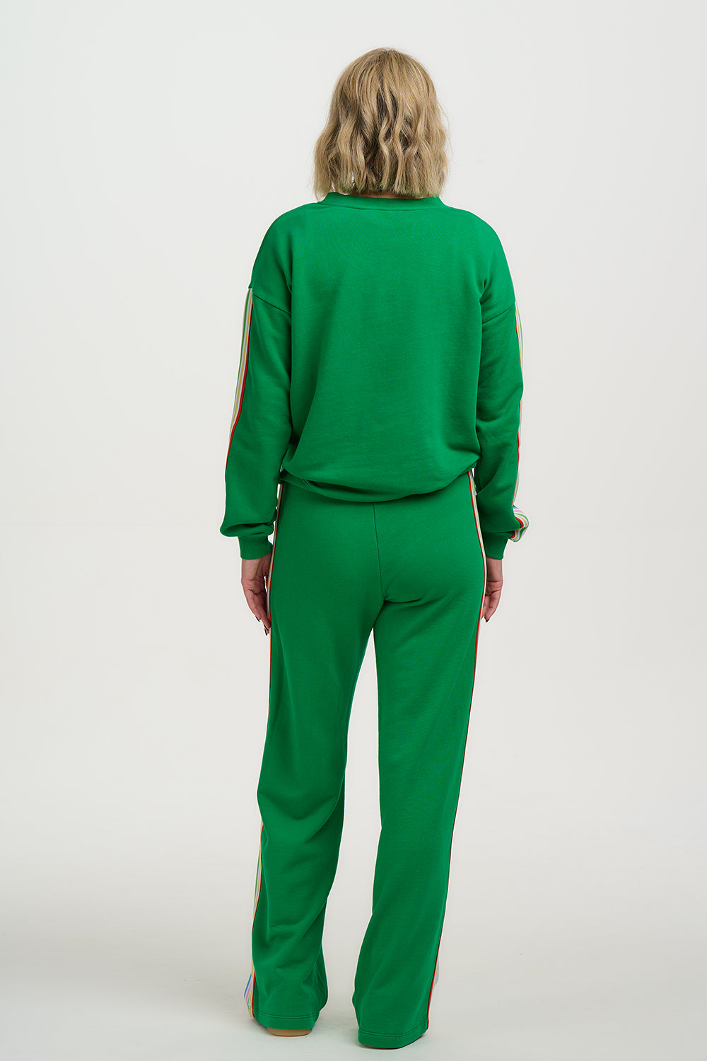 Person wearing a green tracksuit on a white background