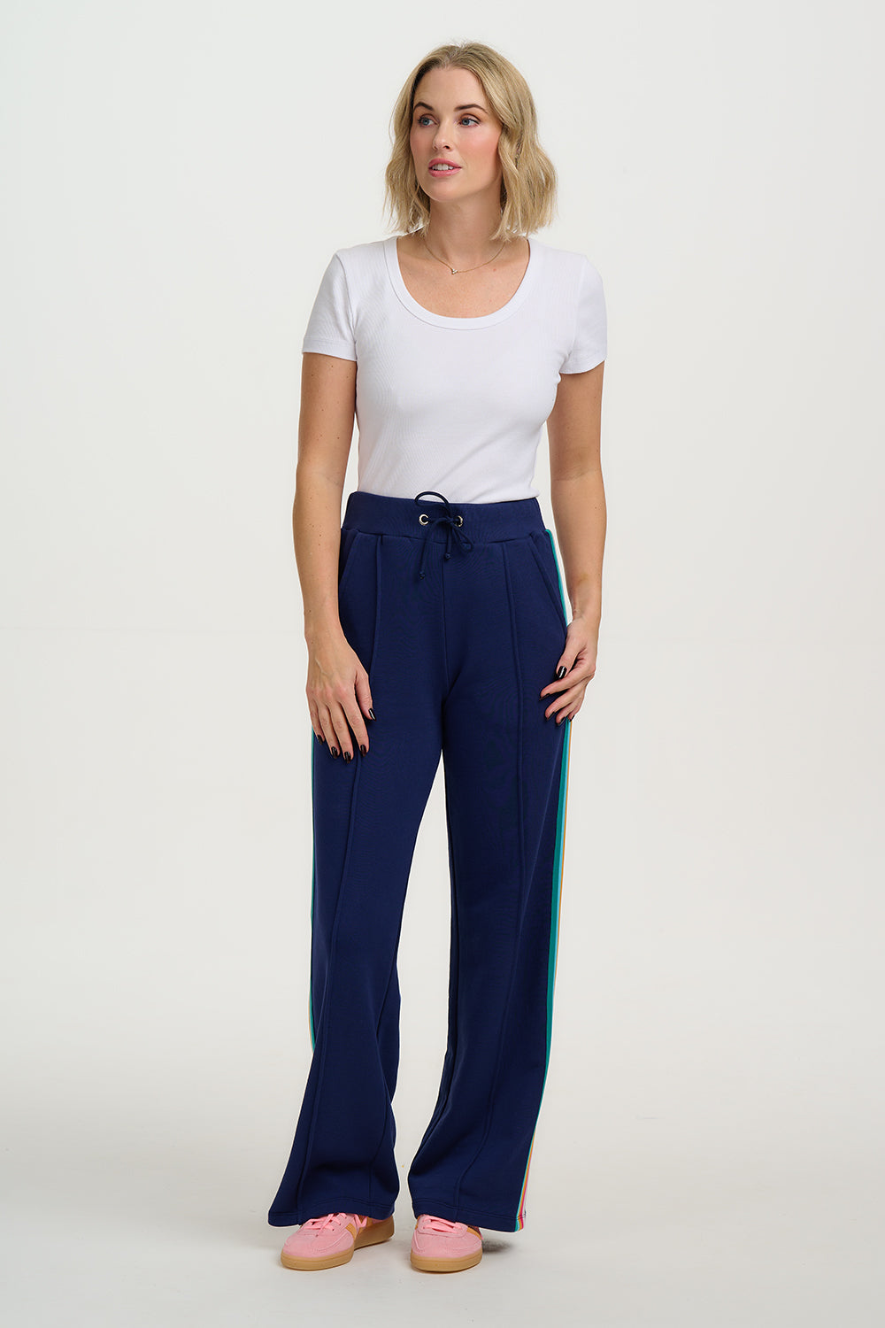 Woman wearing a white top and blue pants on a white background
