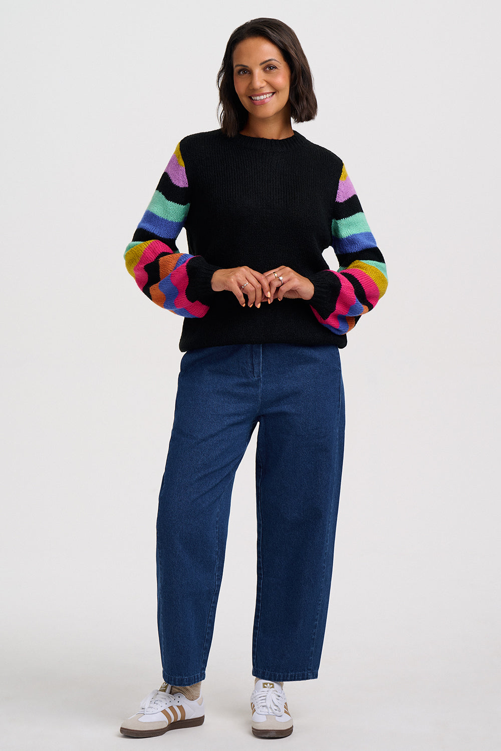 Black jumper with colorful striped sleeves on a white background