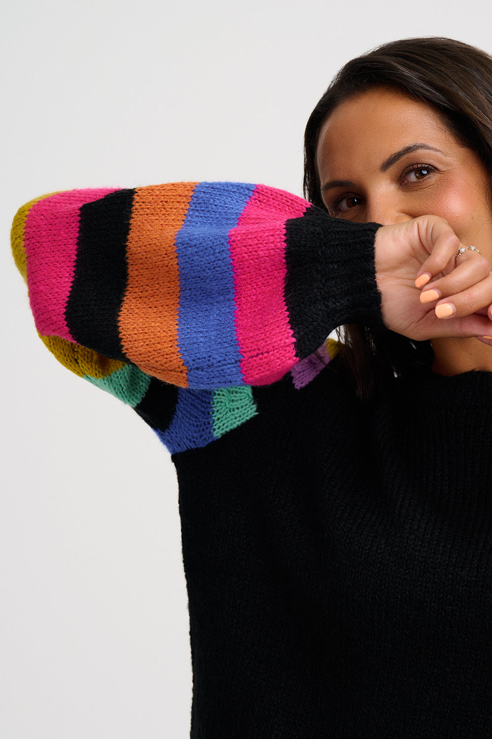 Black jumper with colorful striped sleeves on a white background