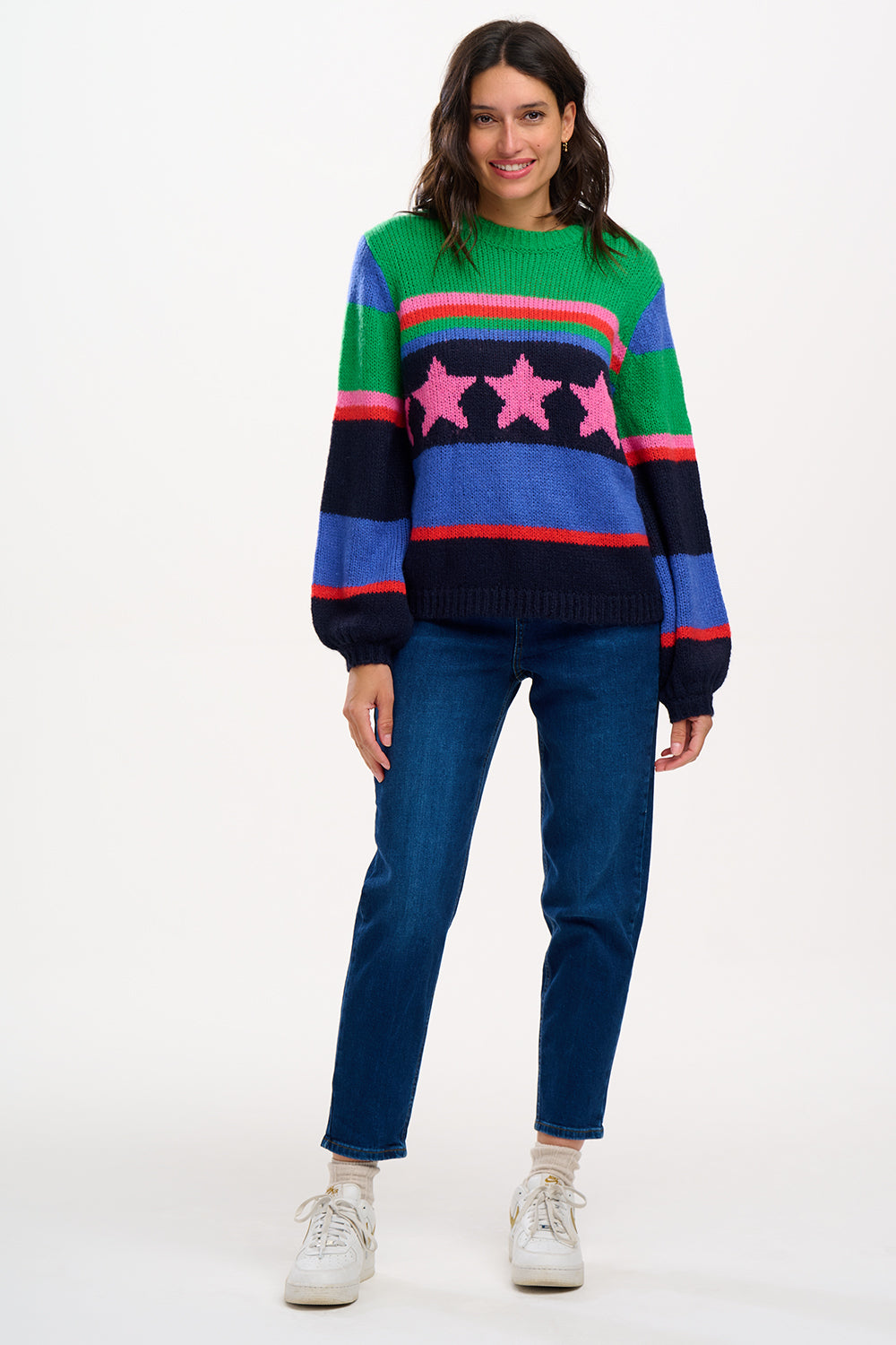 A woman wearing a colorful striped sweater with a pattern of stars.