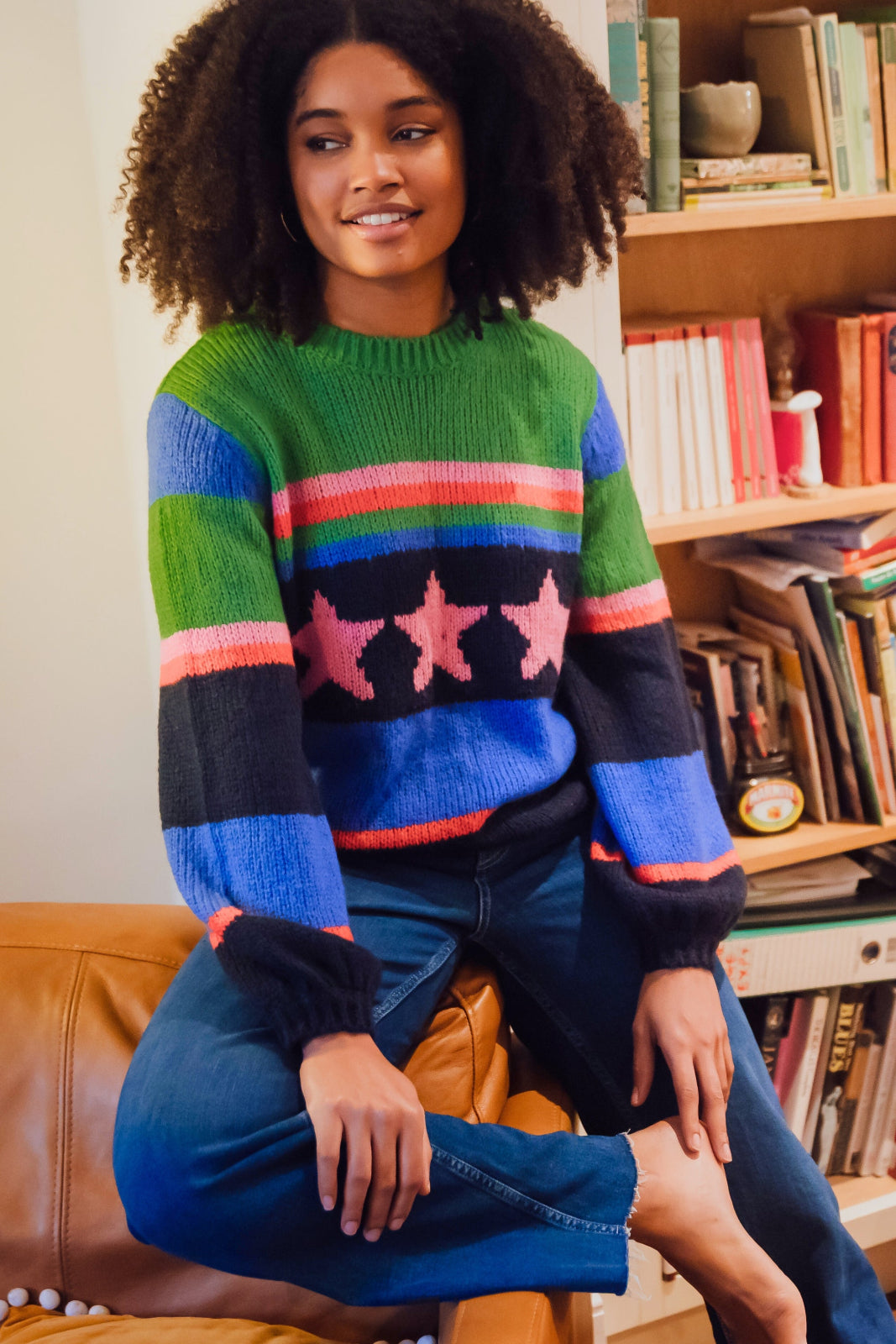 A woman wearing a colorful striped sweater with a pattern of stars.