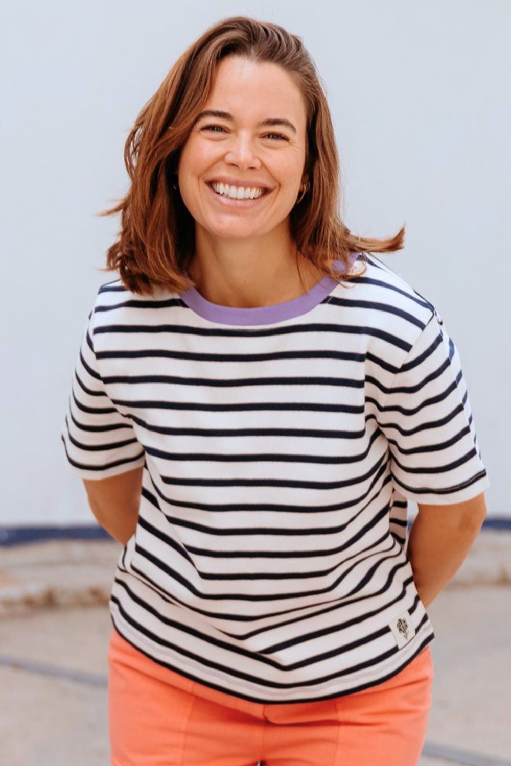 Woman wearing a striped shirt and blue pants on a white background