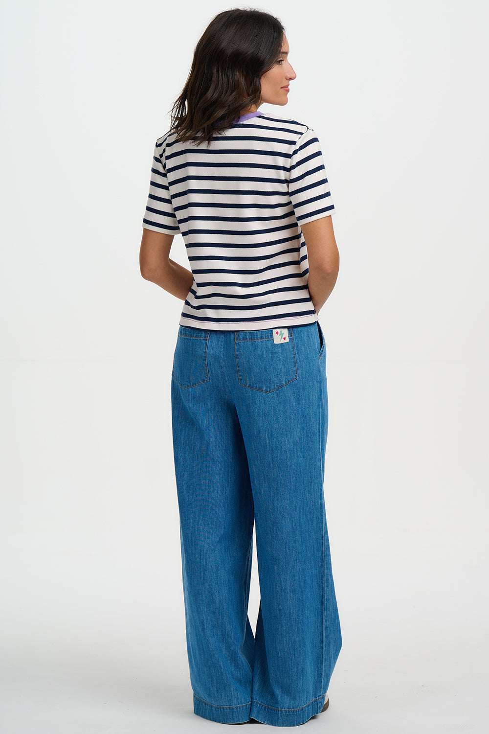 Woman wearing a striped shirt and blue jeans on a white background
