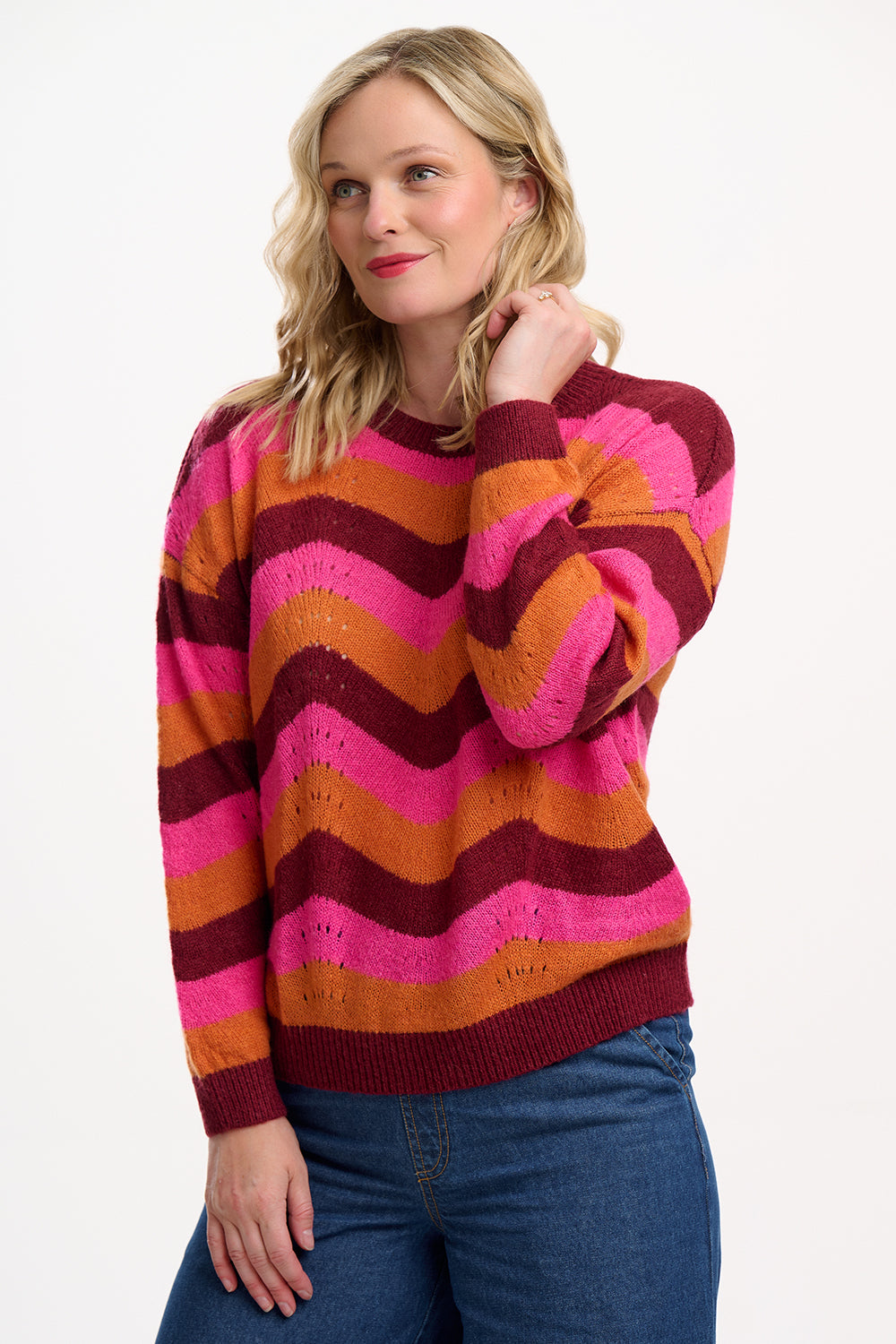 Woman wearing a colorful striped sweater on a white background