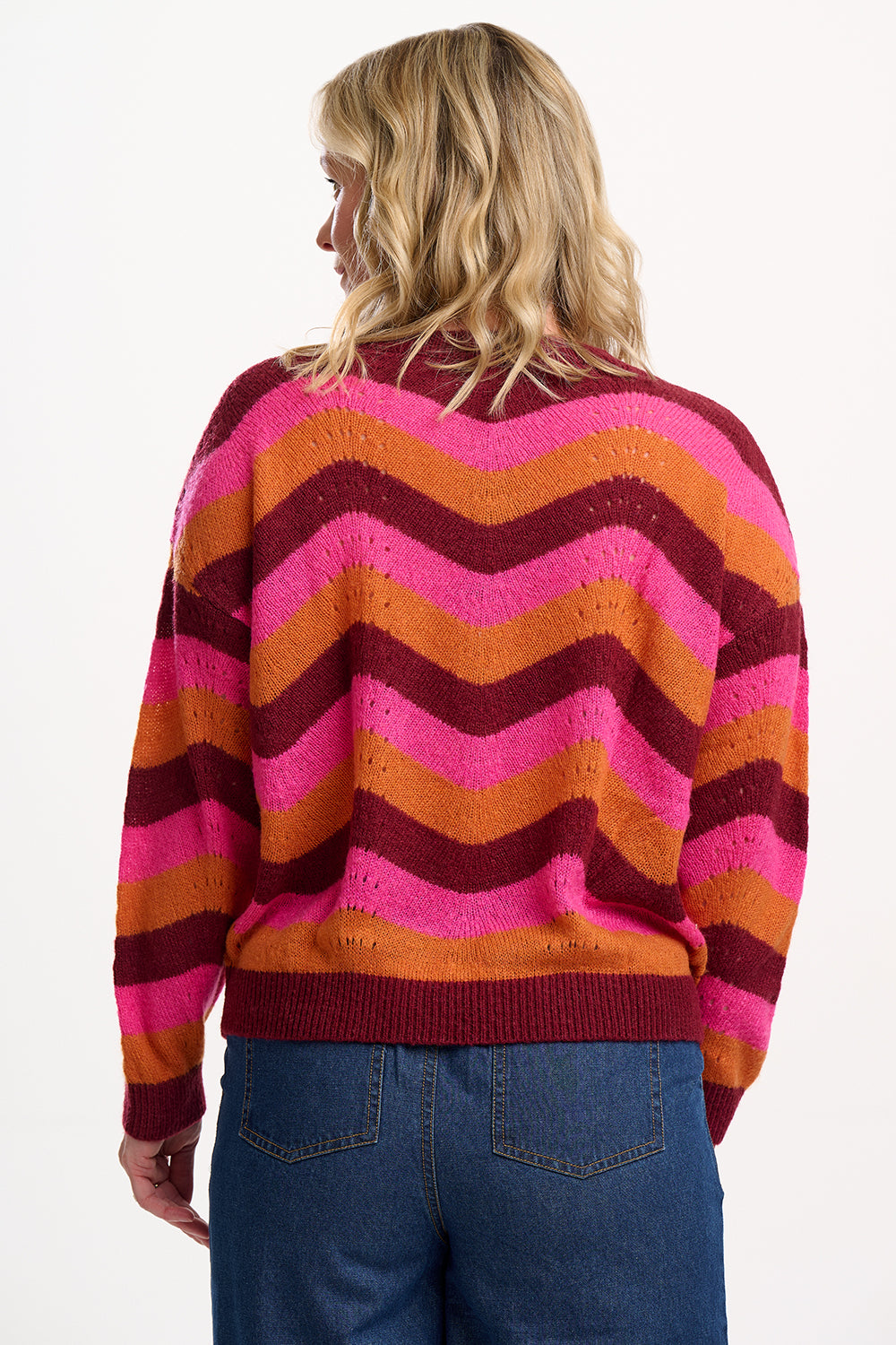 Person wearing a colorful striped sweater on a white background