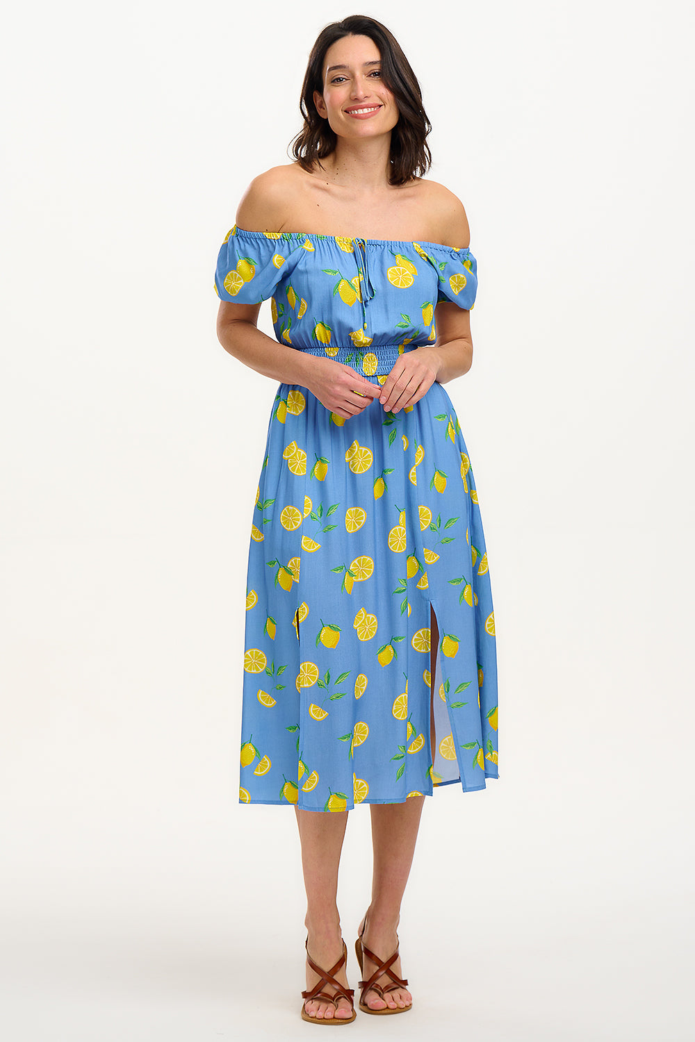 A woman modeling a midi dress with an off-the-shoulder neckline, featuring a blue color with yellow lemon print. The dress has frill-cuffed short sleeves and two front splits in the skirt.