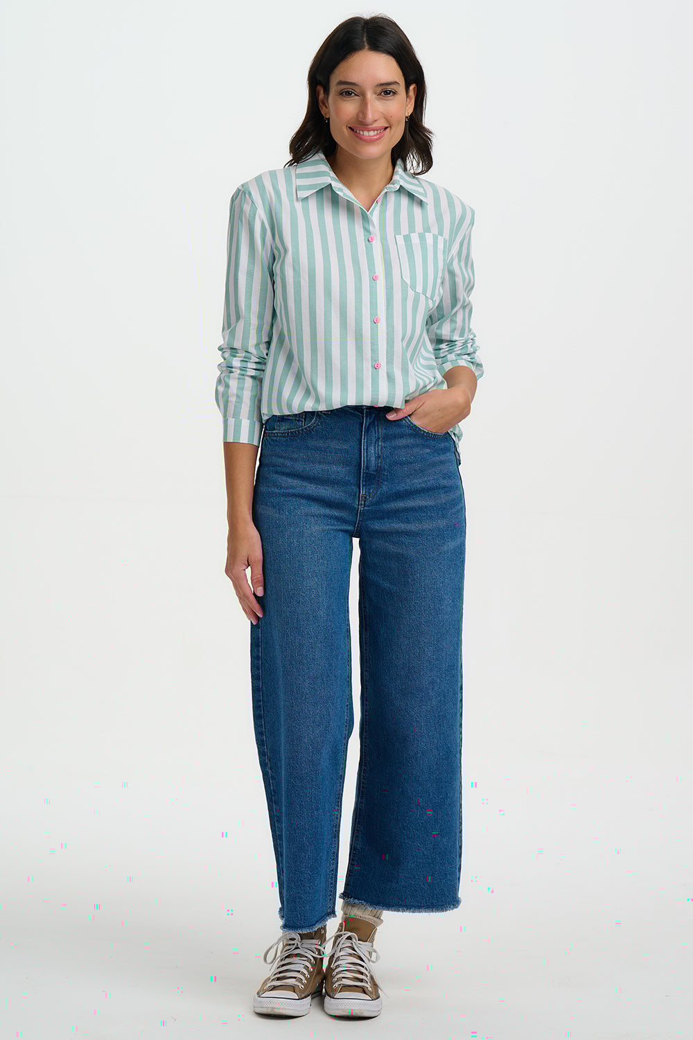Woman wearing a striped shirt and blue jeans on a white background