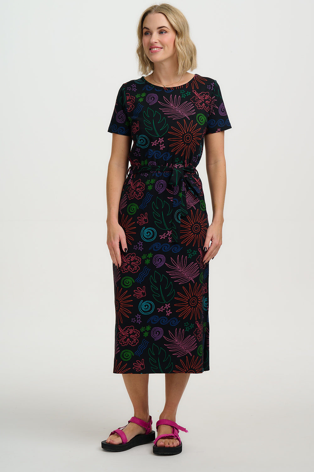 Woman wearing a dark dress with colorful abstract patterns on a white background