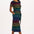 A model wearing a midi-length jersey dress with a black background featuring a vibrant multicolour striped pattern. The dress has a t-shirt fit with a matching tie belt and short sleeves.