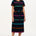A model wearing a midi-length black dress with vibrant colored stripes, featuring a matching tie belt and short sleeves.