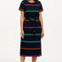 A model wearing a midi-length black dress with vibrant colored stripes, featuring a matching tie belt and short sleeves.