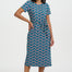 Woman wearing a blue patterned dress on a white background