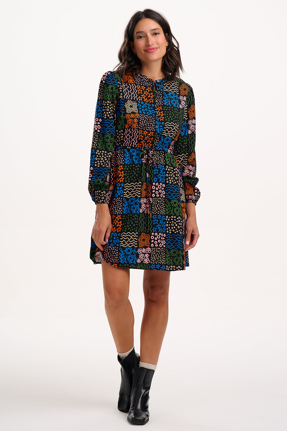 Woman wearing a colorful patchwork dress on a white background