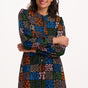 Woman wearing a colorful patterned dress on a white background