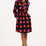 Woman wearing a black dress with colorful polka dots on a white background