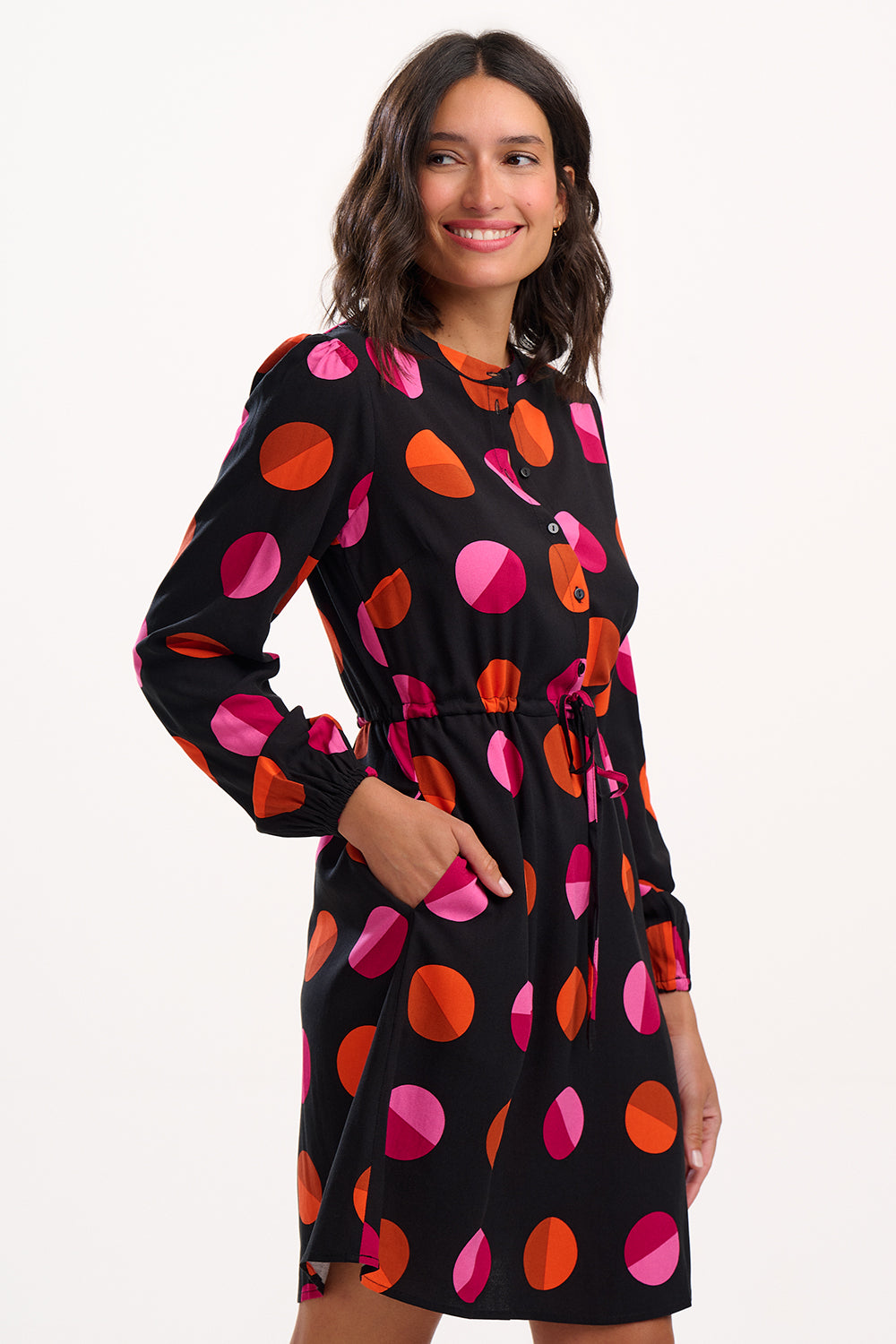 Woman wearing a black dress with colorful abstract patterns on a white background