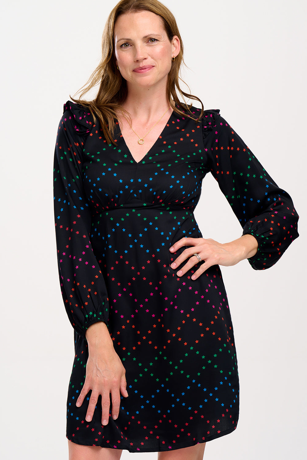 Woman wearing a black dress with colorful polka dots.