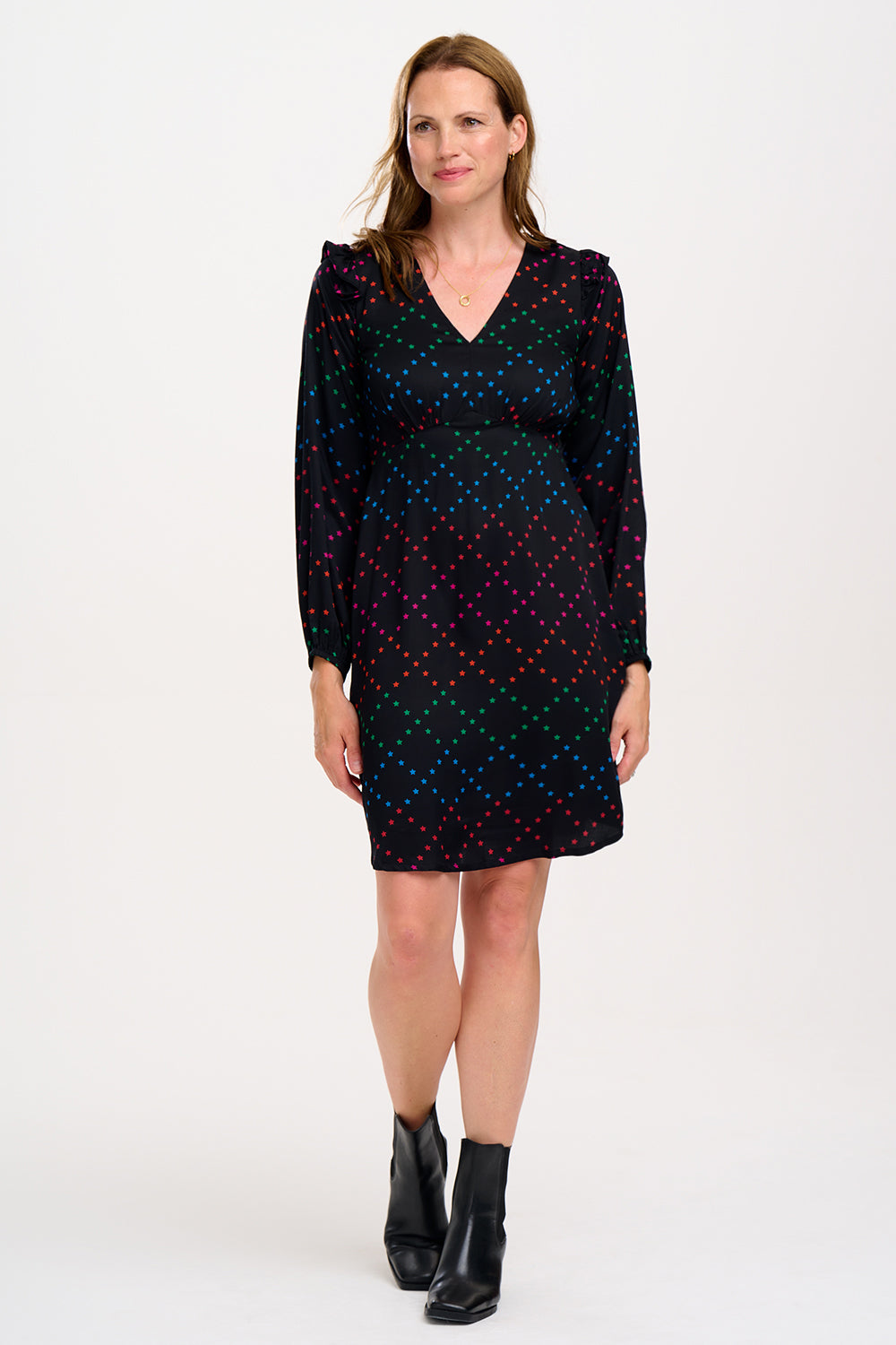 Woman wearing a black dress with colorful polka dots.