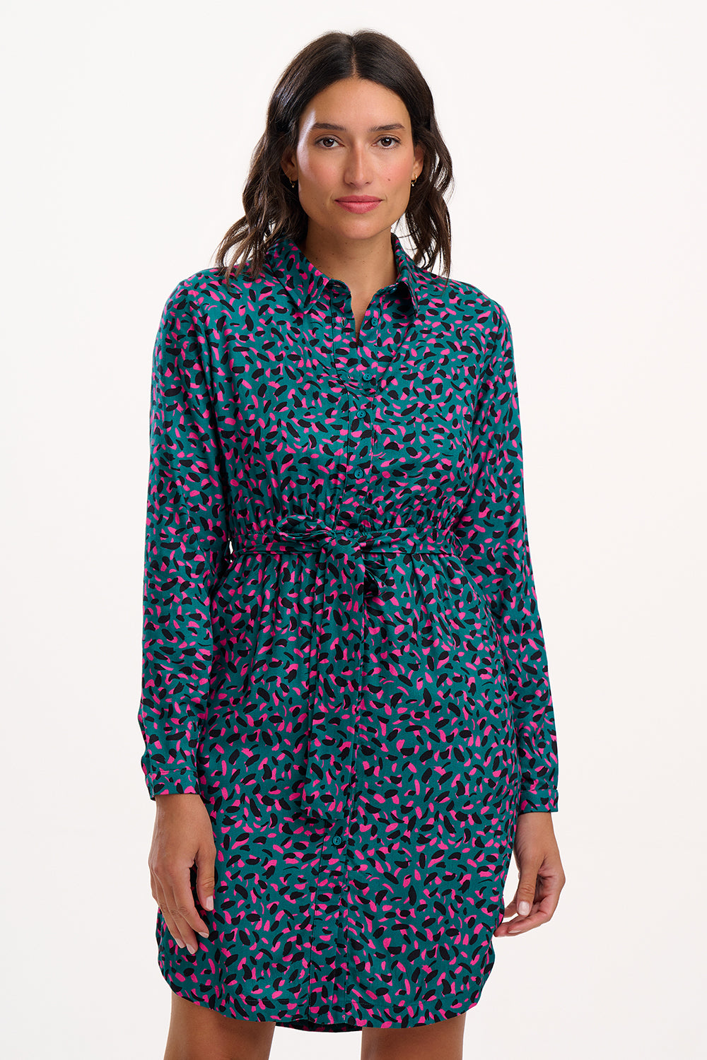 Woman wearing a patterned shirt dress on a white background