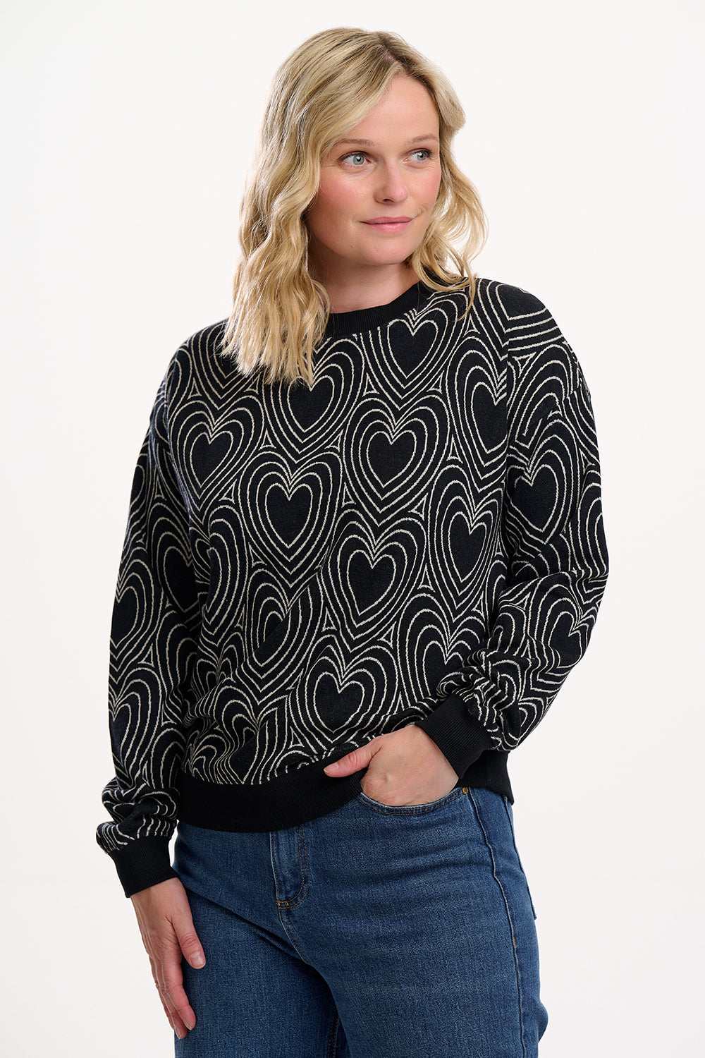 Woman wearing a black sweater with heart pattern on a white background