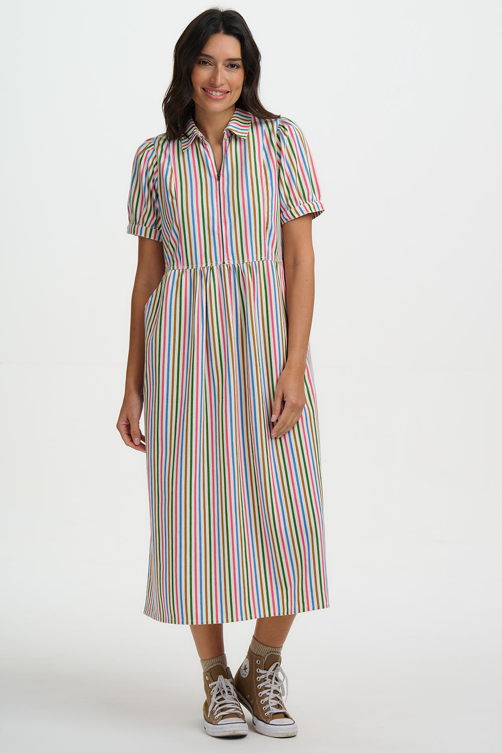 Woman wearing a colorful striped dress on a white background
