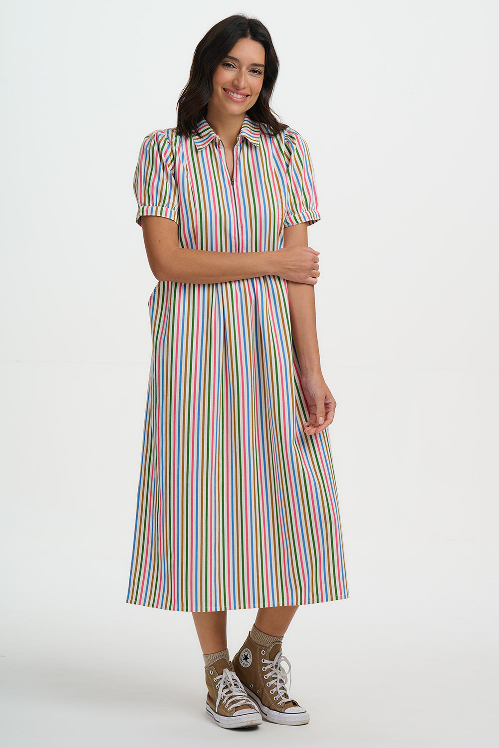 Woman wearing a colorful striped dress on a white background