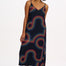 A model wearing a midi-length sundress with a black base and multicolored geometric patterns, featuring adjustable spaghetti straps.