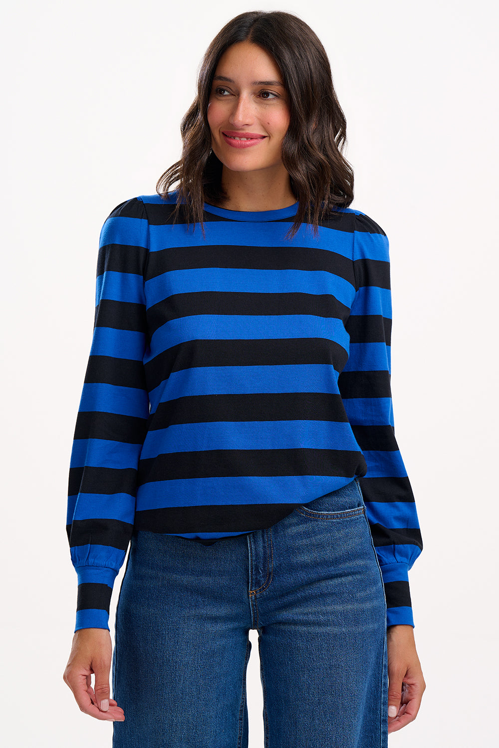 Woman wearing a blue and black striped sweater with jeans on a white background