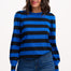 Woman wearing a blue and black striped sweater with jeans on a white background
