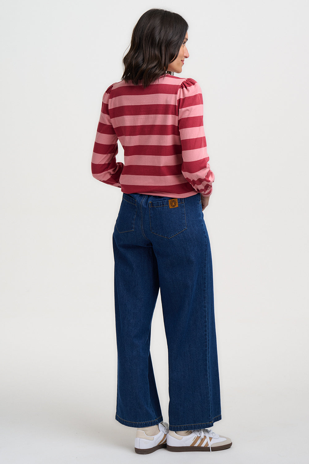 Person wearing a red and white striped shirt and blue jeans on a white background