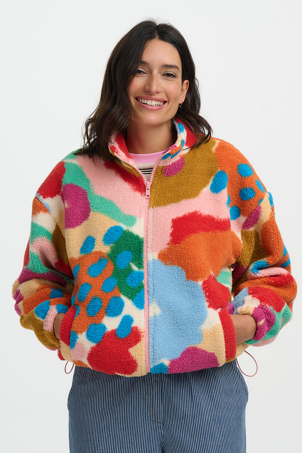 Woman wearing a colorful patterned jacket on a white background