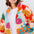 Person wearing a colorful, patterned jacket with a white shirt underneath.
