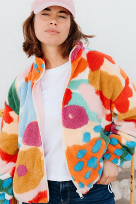 Person wearing a colorful, patterned jacket with a white shirt underneath.