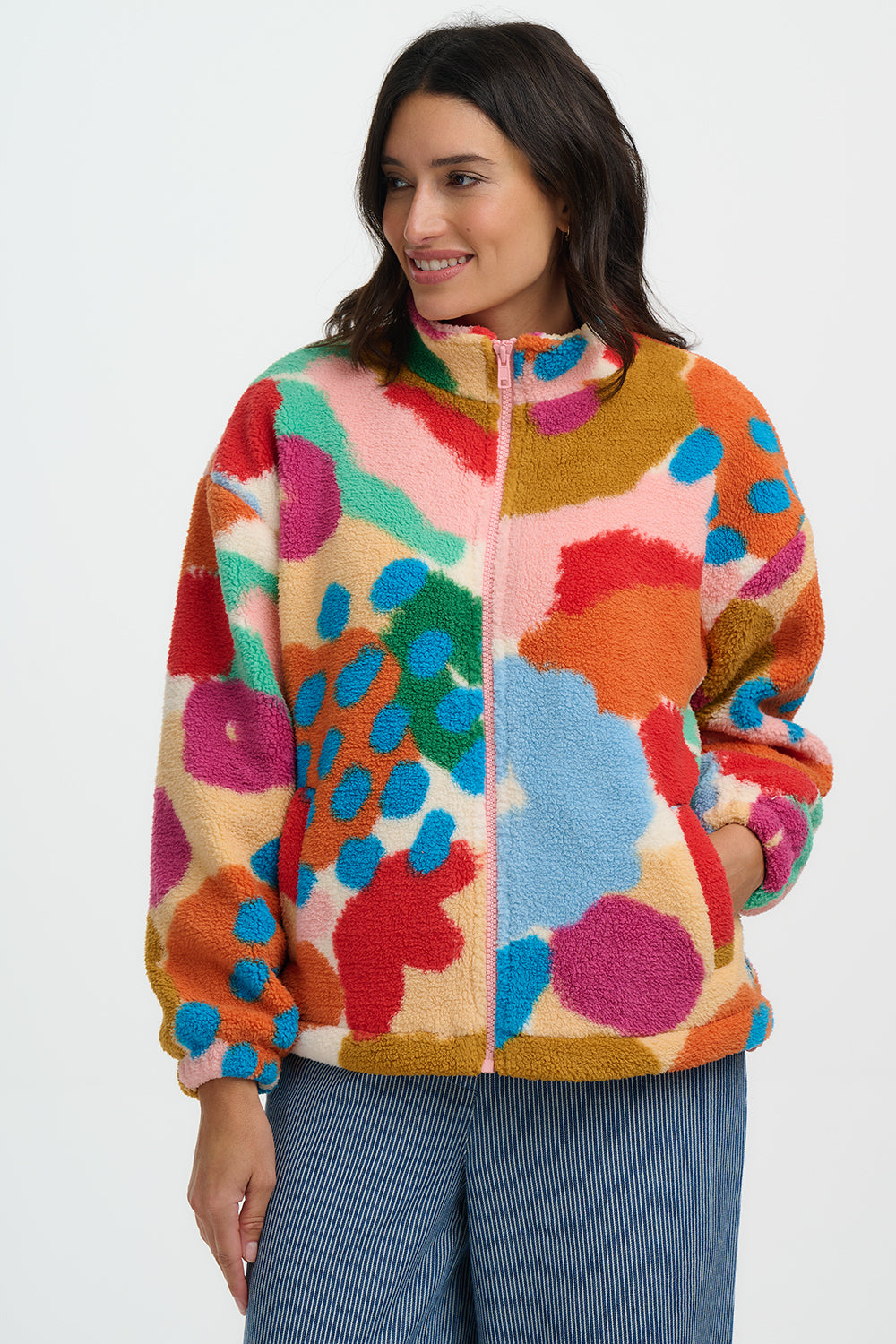Woman wearing a colorful patterned jacket on a white background