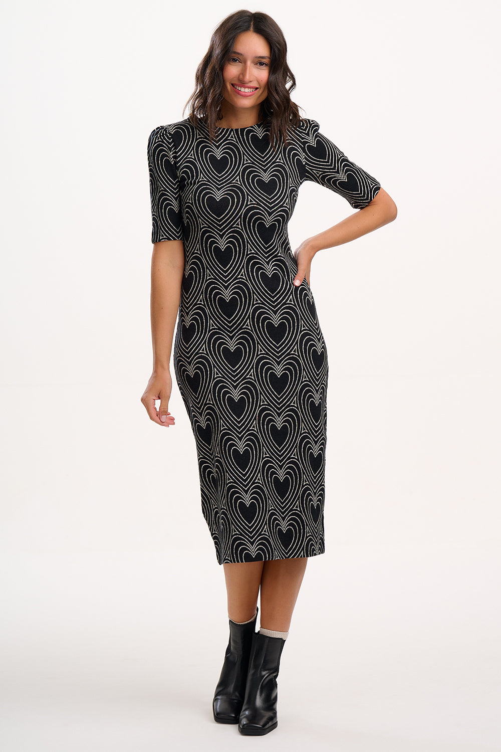 Woman wearing a black dress with heart pattern on a white background