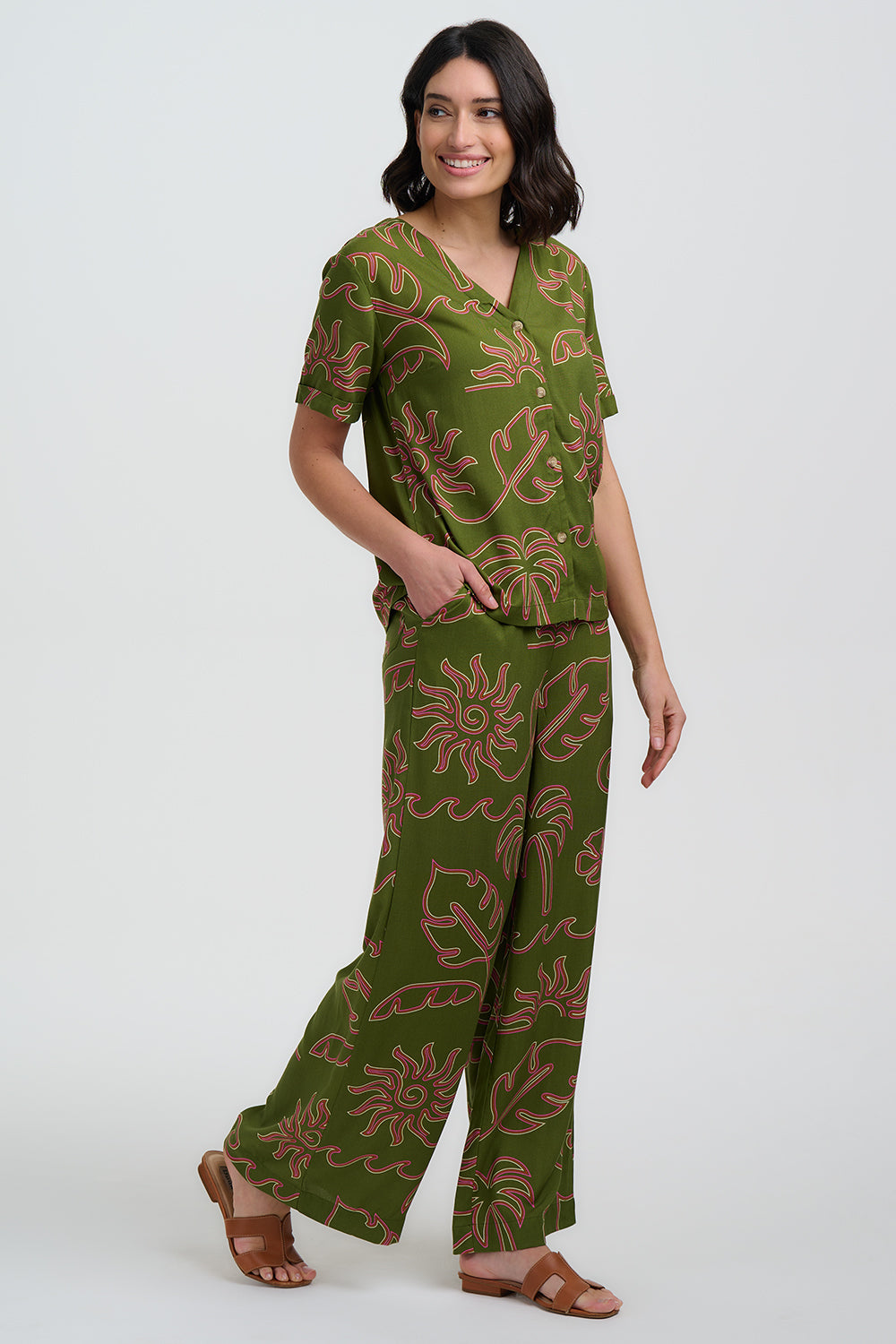 Woman wearing a green patterned outfit on a white background