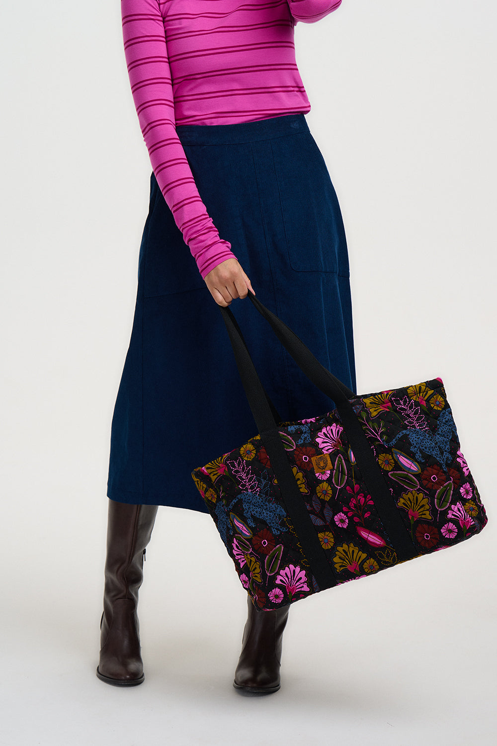 Person holding a floral-patterned bag against a white background